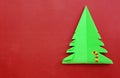 Origami Christmas tree paper on red background.