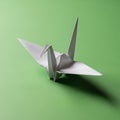 Origami crane made from white paper placed on a green surface. The crane features Royalty Free Stock Photo