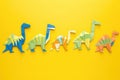 origami dinosaurs arranged in a row on a bright yellow background