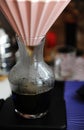 Origami filter dripping coffee into a glass carafe close up. Electronic scale. Alternative manual brewing