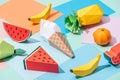 Origami ice cream and handmade cardboard fruits on multicolored paper.