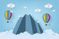 Origami made colorful hot air balloon flying over the mountain with cloud.Paper art style. Royalty Free Stock Photo