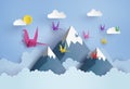 Origami made colorful paper bird flying on blue sky