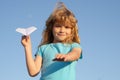 Origami paper airplane. Kid boy throwing a paper plane with blue sky background. Royalty Free Stock Photo