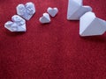 Origami paper hearts shape symbols for Valentines Day, With gift ribbon with red hearts. Copy space for text Royalty Free Stock Photo