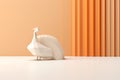 an origami peacock standing in front of an orange wall