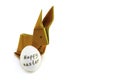 Origami rabbit from orange colored paper. Easter bunny and white chicken egg with the inscription Happy Easter on a white Royalty Free Stock Photo