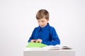 Origami: studious boy  with scissors is studying the book to make Royalty Free Stock Photo