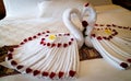 Origami swans made out of towels and laid out on a bed in a honeymoon suite