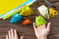 Origami toy made from paper puppets cat. Glue, scissors and paper on a wooden table. Royalty Free Stock Photo