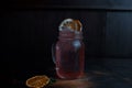 Original alcoholic pink cocktail with tequila and vodka with raspberry syrup, decorated with dried and fresh orange slices on a Royalty Free Stock Photo