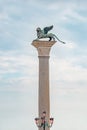 Original ancient top tower sculpture of symbol of Venice winged lion at the Piazza San Marco in blue milky sky with copy space for