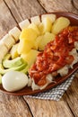 Original Bermudian breakfast consists of salted codfish, boiled potatoes, bananas, boiled eggs and avocado close-up on a plate.