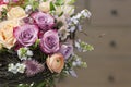 Original bouquet with roses, ranunculuses in a skeleton from branches