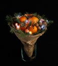 Original Christmas bouquet consisting of persimmon, mandarins, nuts, cinnamon sticks and pine twigs wrapped in kraft paper and dec