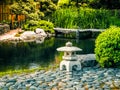 The original design of the landscape in the Japanese style. Stone lantern placed near the pond in the Japanese garden. Royalty Free Stock Photo