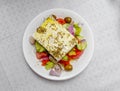 Original feta cheese in Greek salad with tomatoes cucumbers, olives and onions plate Royalty Free Stock Photo