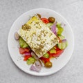 Original feta cheese in Greek salad with tomatoes cucumbers, olives and onions plate Royalty Free Stock Photo