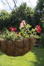 Original flowerpot with flowers hanging at the entrance to the house