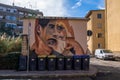 Original graffiti on the wall near the smidt tanks depicting extravagant faces on the street of Cagliari, Sardinia