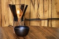 Beautiful warm still life of old wood in the form of a table lamp and a clay bowl