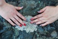 Original manicure with a skull and bones of red and silvery-gray color against the background of a rock of volcanic rock