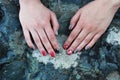 Original manicure with a skull and bones of red and silvery-gray color against the background of a rock of volcanic rock