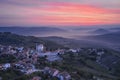 An original mountain village in the first rays of the rising sun. At the foot of the mountains, the morning fog creeps. Shooting f Royalty Free Stock Photo