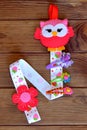 Original organizer for hairpins, a felt owl, a set of barrettes. Kids crafts. Brown wooden background