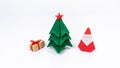 Original origami Christmas holiday card. Christmas tree, gift box and Santa Claus folded from paper Royalty Free Stock Photo