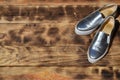 Original shiny shoes in disco style lie on a vintage wooden surface made from fried brown boards. Fashionable clothing retro acce