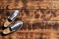 Original shiny shoes in disco style lie on a vintage wooden surface made from fried brown boards. Fashionable clothing retro acce