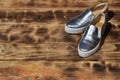 Original shiny shoes in disco style lie on a vintage wooden surface made from fried brown boards. Fashionable clothing retro acce