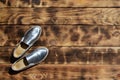 Original shiny shoes in disco style lie on a vintage wooden surface made from fried brown boards. Fashionable clothing retro acce