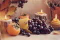 An original still life of Russia with the fire of a wax candle. Candle flame close-up. Still life with blue grapes and persimmons. Royalty Free Stock Photo