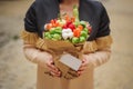 The original unusual edible vegetable and fruit bouquet with card in woman hands