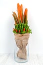 An original vegetable bouquet consisting of carrots, pea pods, lettuce leaves, red pepper and aloe is stand in a glass vase Royalty Free Stock Photo