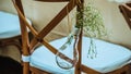 Original wedding floral decoration, mini-vases and bouquets of flowers hanging from the chair