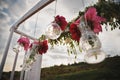 Original wedding floral decoration in form of mini vases and bouquets of flowers hanging from wedding altar, outdoor beach wedding Royalty Free Stock Photo