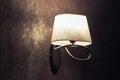 Original white lamp, sconce on a brown wall in vintage style