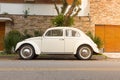 Original 1961 white Volkswagen Beetle parked in front of residence