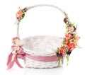 Original wicker basket with a beautiful, delicate pink decor with a pink ribbon around the basket. On a white background