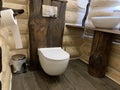 Original wooden bathroom design. Wall-mounted toilet in a wooden house Royalty Free Stock Photo