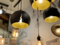 Original yellow-black ceiling lights. Modern chandeliers in the electrical goods store. Pendant floor lamps for interior