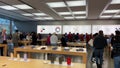 An Apple store with people waiting to purchase Apple Macbooks, iPads and iPhones