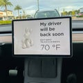 A Tesla set on dog mode to keep the air conditioning on for the car owners canine companion while they are parked in a parking lot Royalty Free Stock Photo