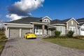 A residential home with an expensive Porsche Spyder in the driveway