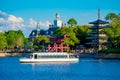 Panoramic view of Japan Pavilion ,American Adventure Pavilion and taxi boat on blue lake at Epcot in Walt Disney World .