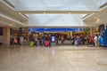 People walking with baggage to different terminals and top view of Ticketing and Check-in blue sign at Orlando International Airpo