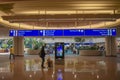 Woman looking at Visitor Center screen and top view of Ticketing and Check-in blue sign at Orlando International Airport . Royalty Free Stock Photo